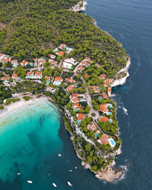 Free Explore the breathtaking aerial view of Cala Galdana, showcasing its turquoise waters and lush greenery. Stock Photo