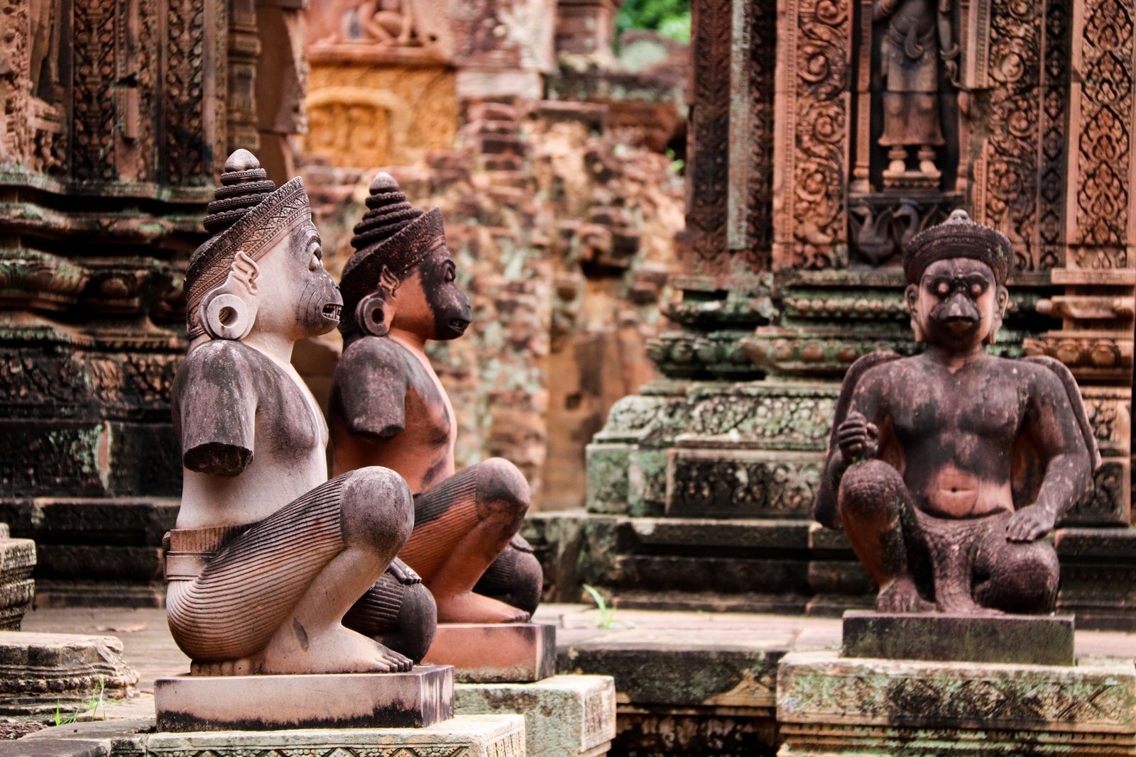 Intricately carved pink sandstone devata figures at Banteay Srei temple, Siem Reap, Cambodia