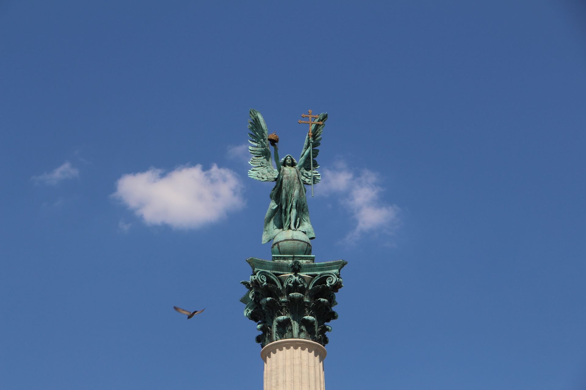 A Bird Flying Near Millennium Monument Under Blue Sky