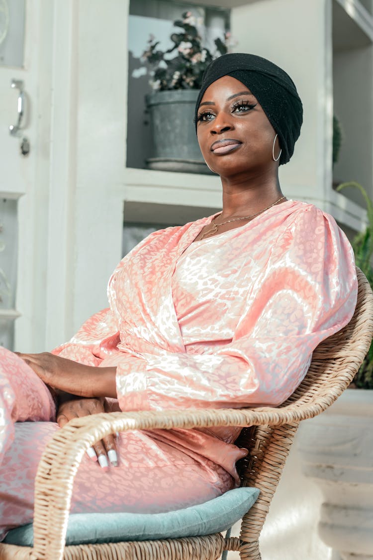 Elegant Woman Sitting On A Chair On A Terrace 