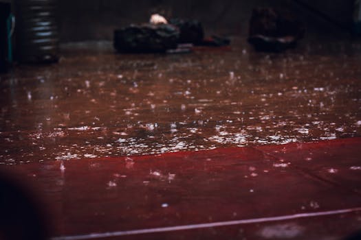 Raindrops splashing on a street surface, creating a reflective wet scene in Kiambu, Kenya.