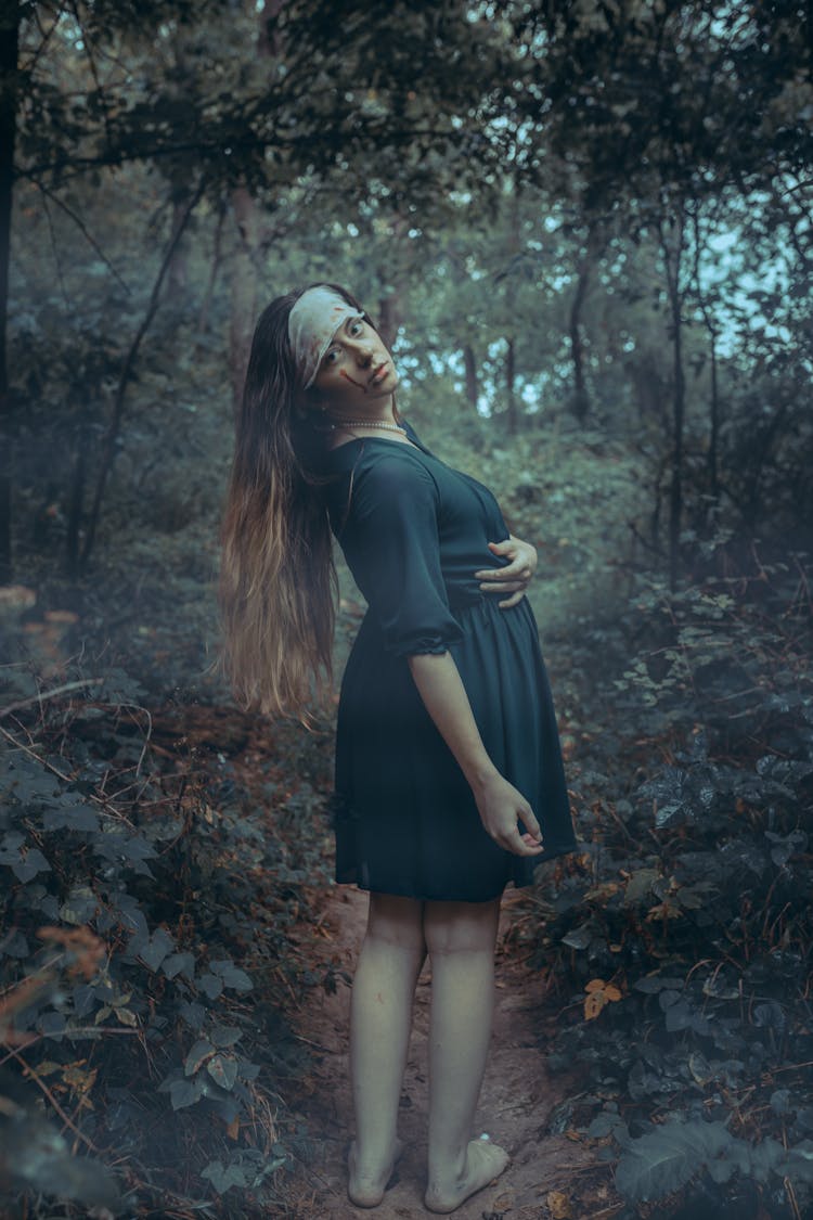 Strange Woman In Dress Posing In Eerie Forest