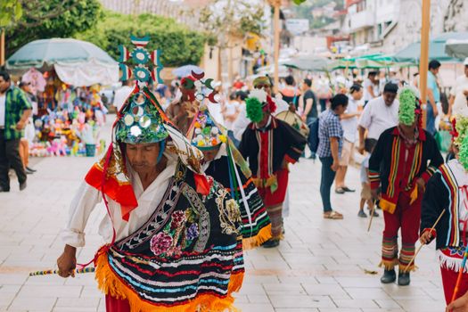 Vibrant traditional dance festival in Papantla, Mexico, showcasing cultural costumes and lively street atmosphere.