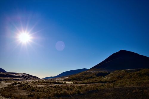 Free Vibrant mountain landscape with bright sun and clear blue sky, capturing natural beauty and tranquility. Stock Photo