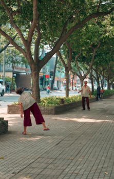 Seniors enjoy outdoor exercise on a sunlit, tree-lined street.