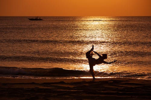 Silhouette of a Woman Doing Yoga at the Beach