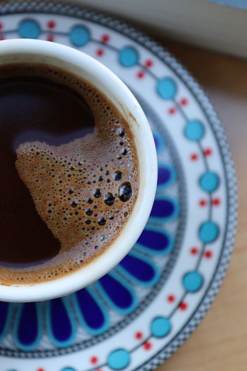 Free Top view of a frothy coffee in a ceramic mug with a decorative saucer. Stock Photo