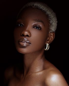 Stunning portrait of a woman with short blonde hair and earrings, exuding confidence and beauty.