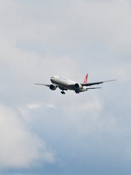 A commercial airplane flying against a cloudy sky in Istanbul, captured during the day.