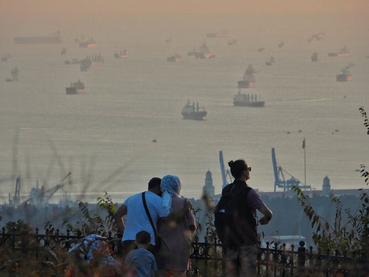 People Looking A At Ships At Dusk