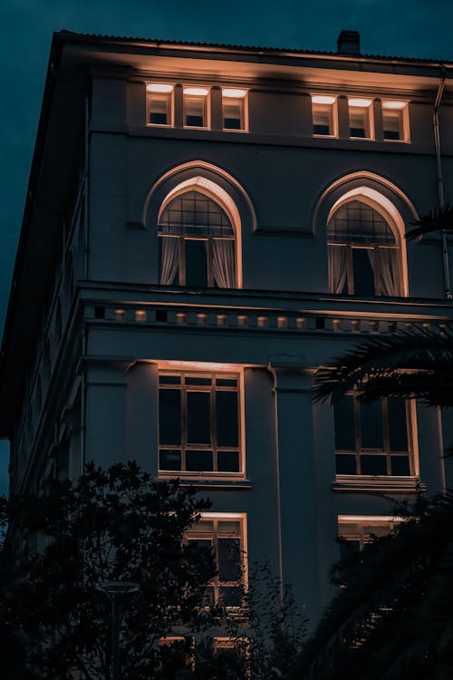 A Low Angle Shot of a Building with Glass Windows at Night