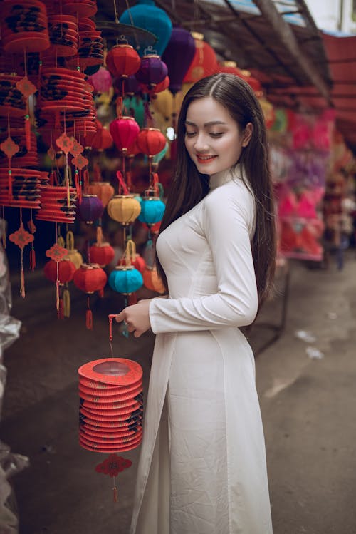 Woman in White Long-sleeved Dress Holding Lantern
