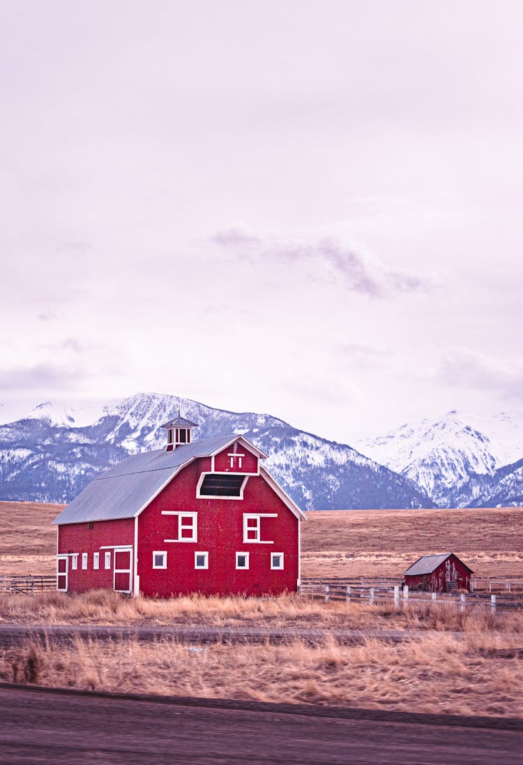 Red Wooden Barn In Mountains