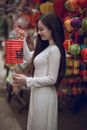 在充满活力的街头市场上，穿着传统服装的妇女们举着灯笼，构成了一幅迷人的文化场景