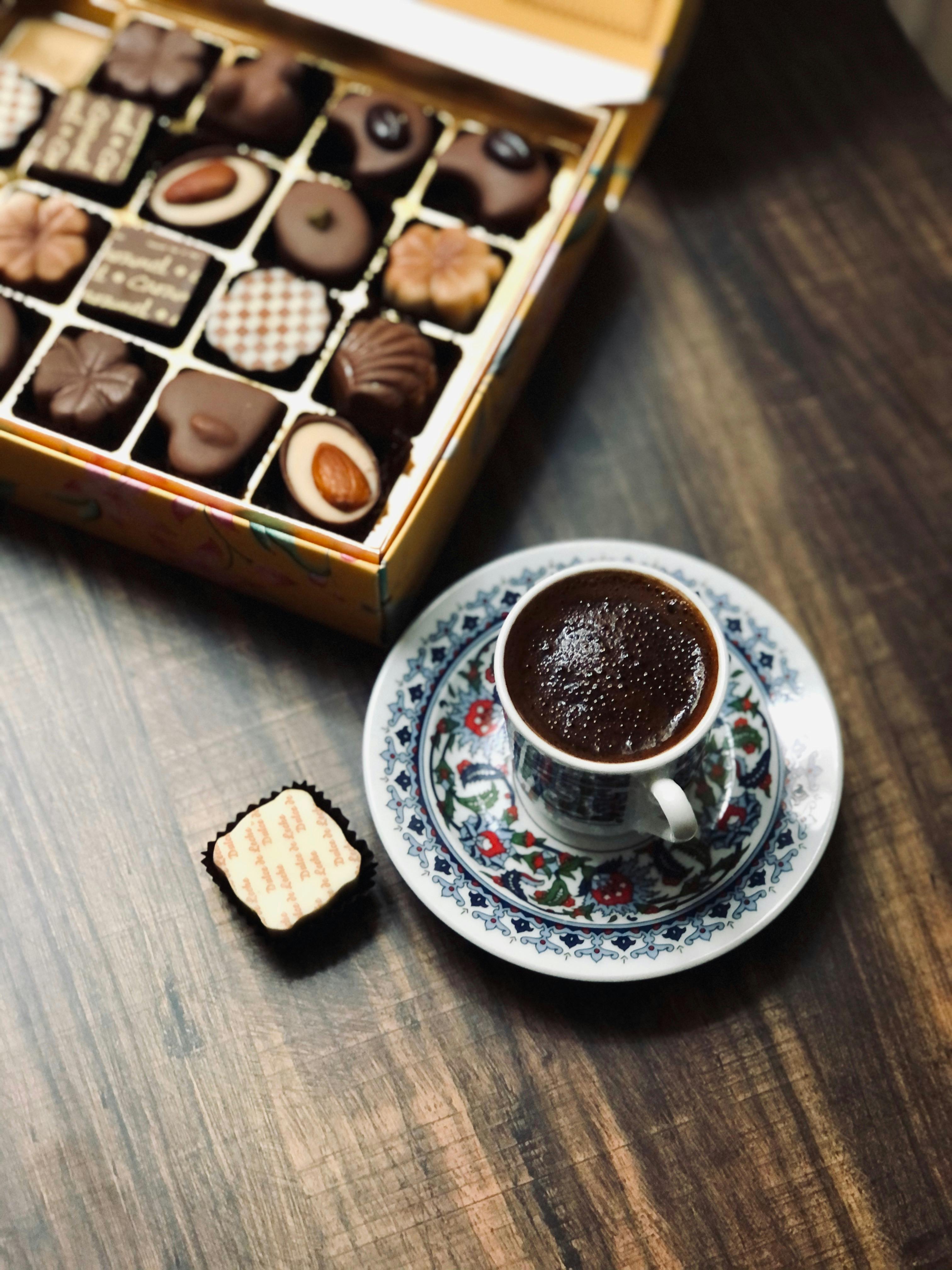 a box of chocolates beside a cup of coffee