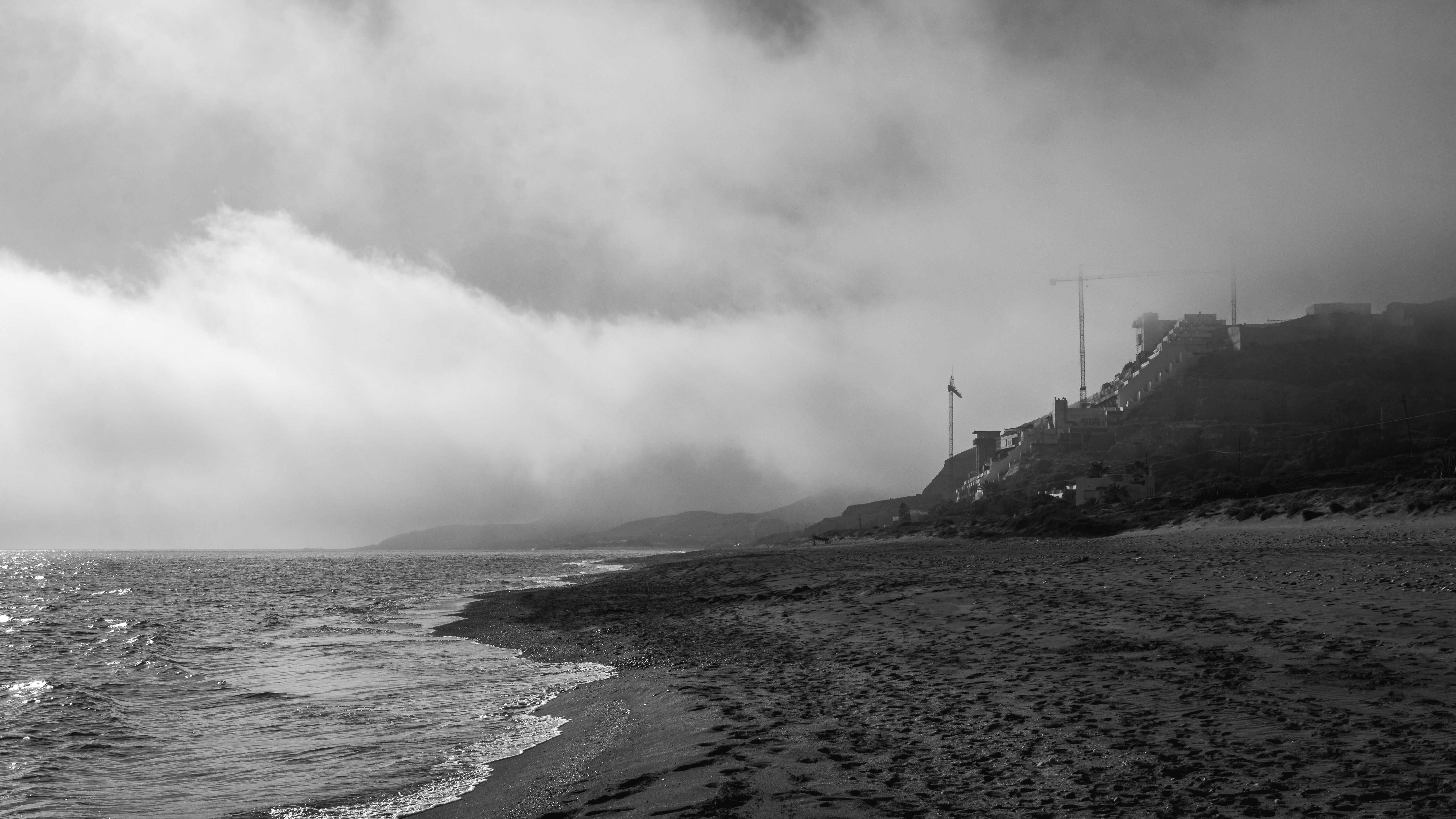 mysterious foggy coastal town at dusk with eerie ocean waves
