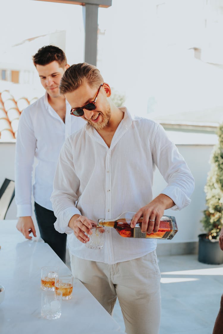 A Man Pouring Whiskey Into A Glass