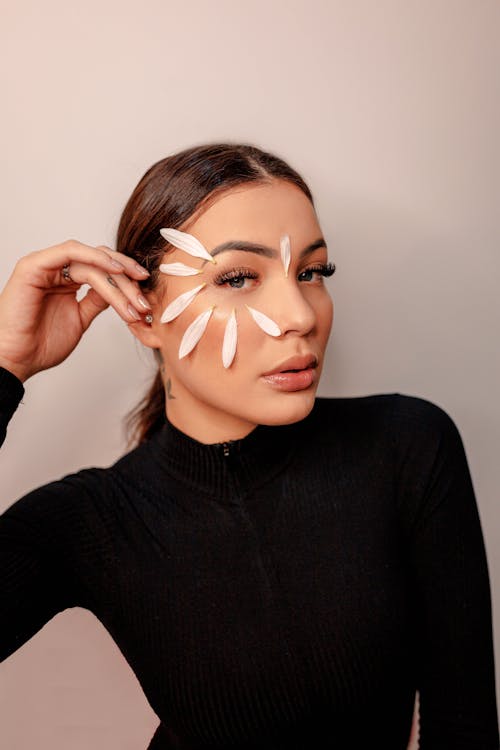 Free A Woman in a Black Long Sleeves Shirt with Flower Petals on her Face Stock Photo