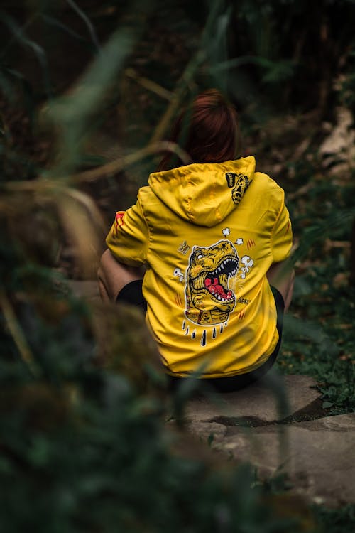 Back View of a Woman in a Yellow Hoodie Sitting