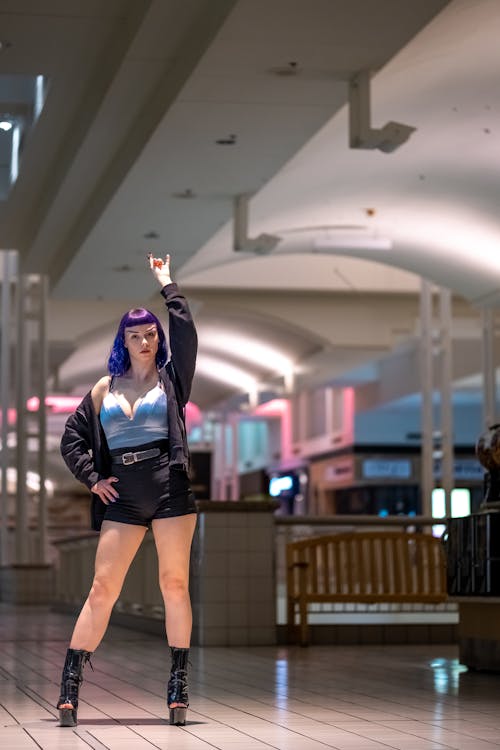 A Woman with Purple Hair Posing with Her Hand Raised