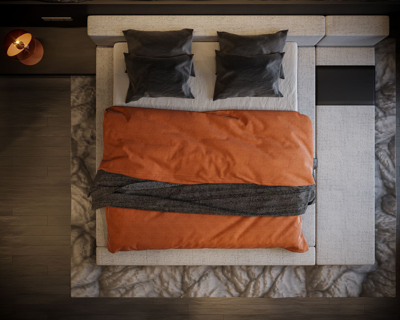 Top-down view of a bed with a terracotta orange duvet, charcoal pillows and a charcoal throw on a cream bed frame