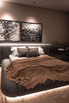 Elegant bedroom featuring modern design, artistic decor, and cozy textiles.