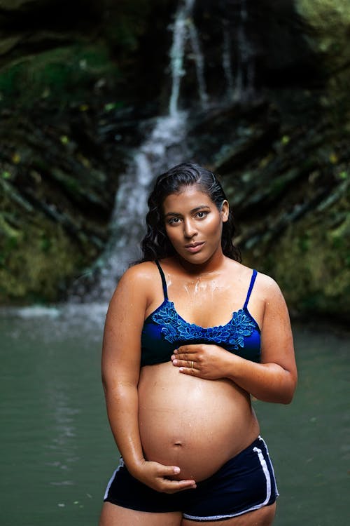 A Pregnant Woman Near a Waterfall