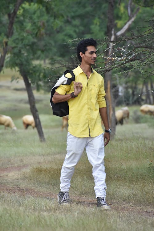 Man in Yellow Shirt Holding a Bag