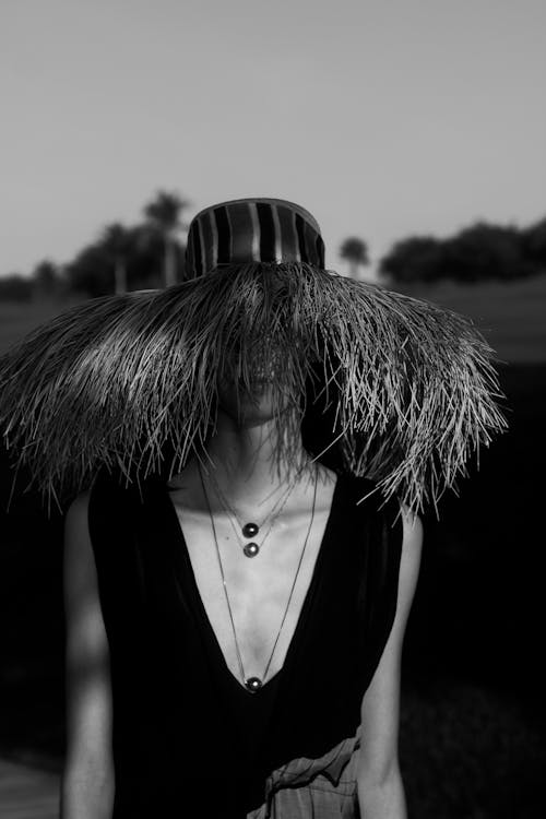 Black and White Photo of a Woman Wearing a Straw Hat 