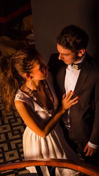 Newlywed couple embracing in warm lighting indoors, capturing romantic ambiance.