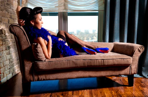 Free Woman in Purple Dress Lying on Brown Couch Stock Photo