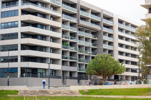 Spacious urban apartment building featuring multiple balconies and a modern architectural design.