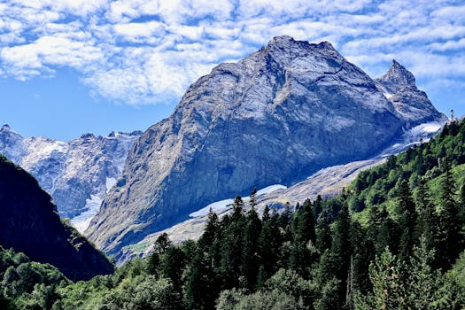 A stunning mountainous scene showcasing rocky peaks and lush greenery below a vibrant sky.