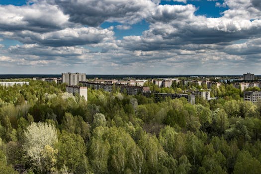 Aerial view of Pripyat in Chernobyl zone, showing abandoned buildings amidst vast greenery.