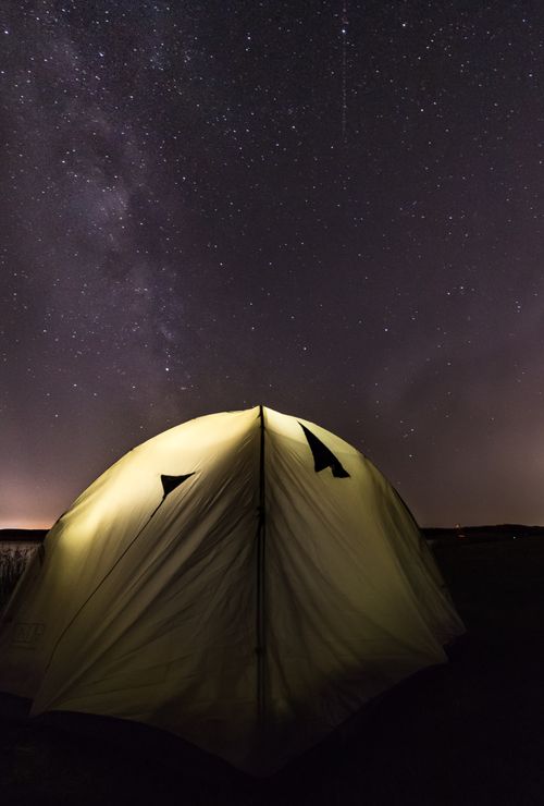 Free Illuminated tent under a star-filled sky in Velence, Hungary, showcasing the Milky Way. Stock Photo