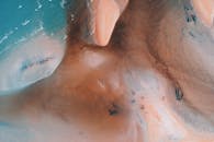 这张航拍的海滩图像令人惊叹，蓝色的海浪与沙质海岸线尽显自然之美