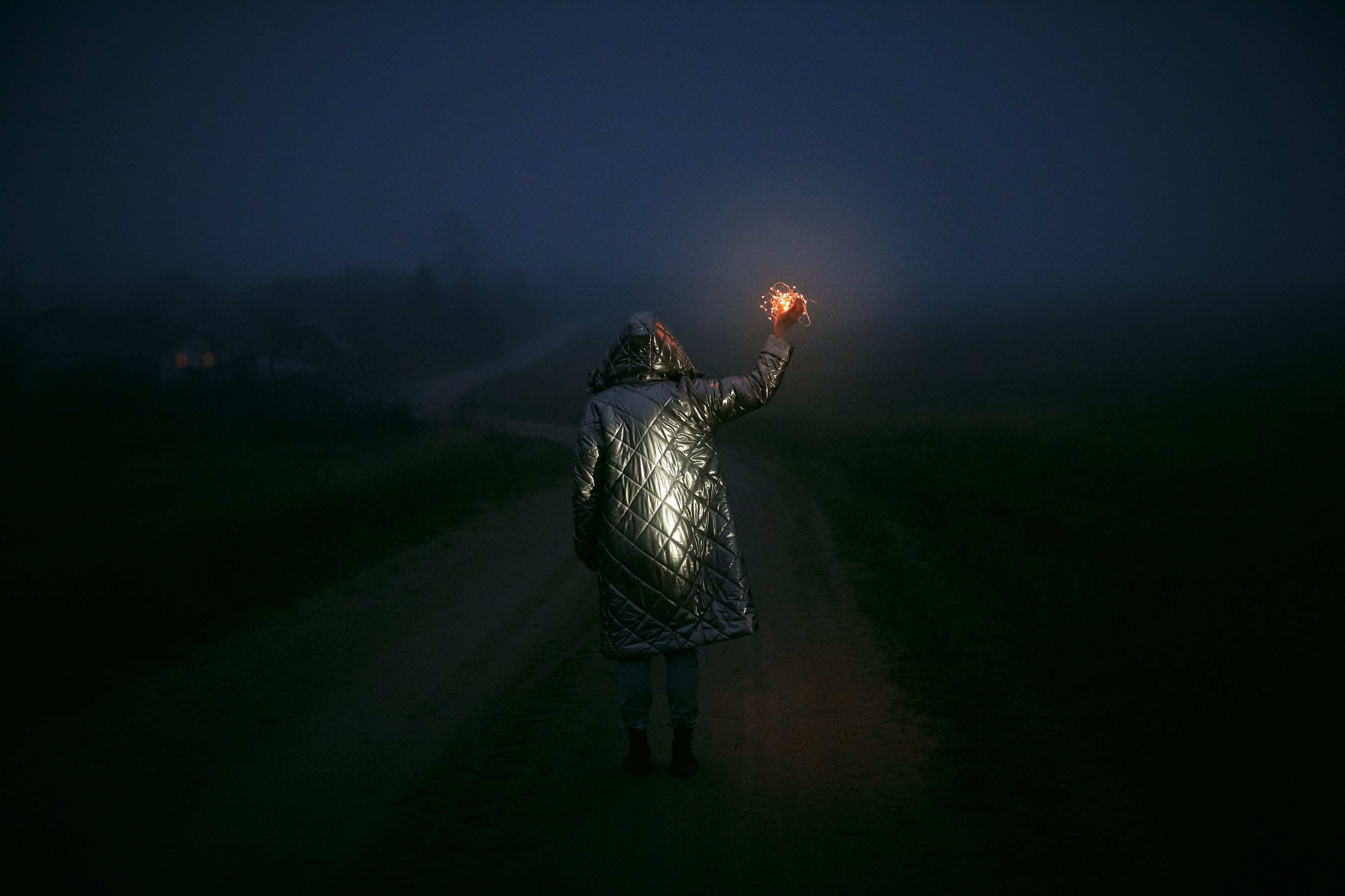 Person standing at a crossroads with a glowing quantum particle sphere above their head
