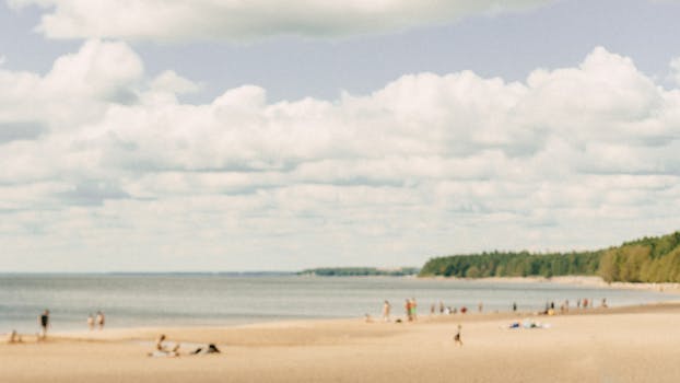 A serene beach scene with tourists relaxing under a cloudy sky.