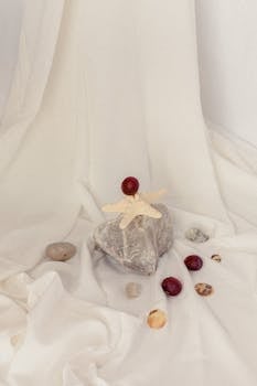 A serene still life featuring a starfish on a stone with scattered shells and chestnuts.