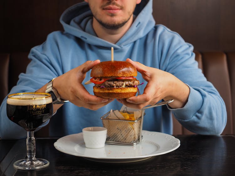 A Person Holding A Burger