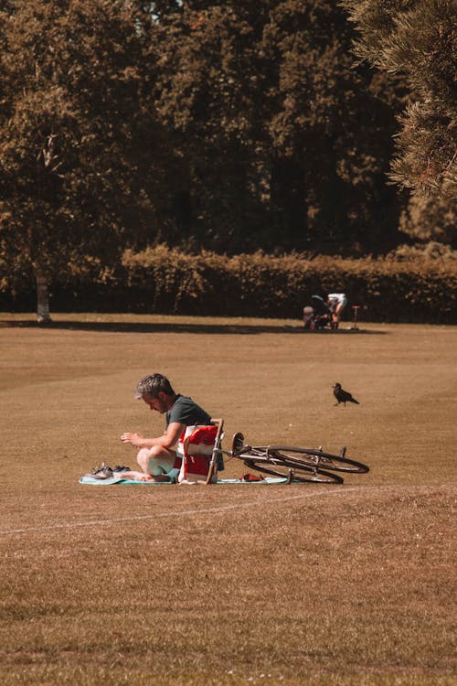 A Man Sitting on Grass Field