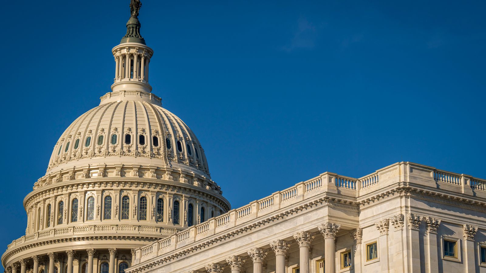 The iconic dome of the United States Capitol against a clear blue sky, showcasing its classical architecture.