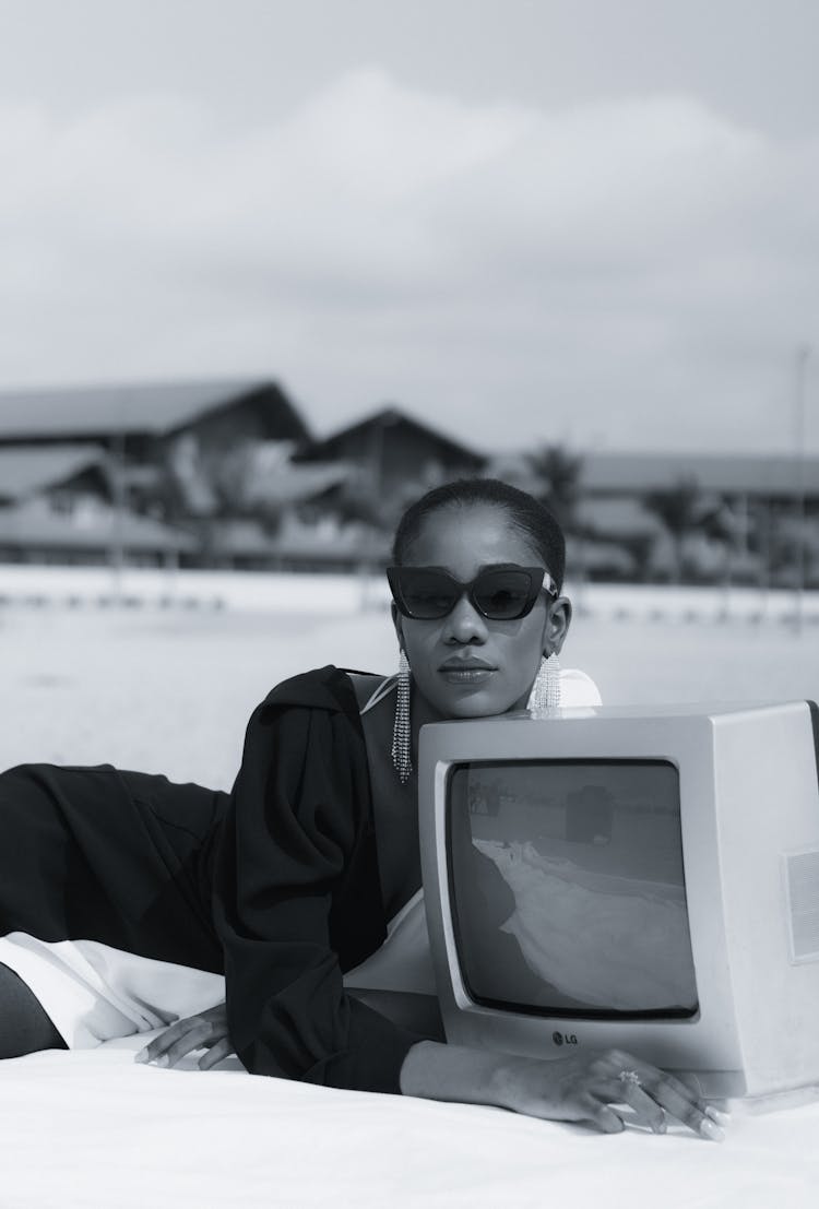 Woman Lying Outdoors With A Retro TV 