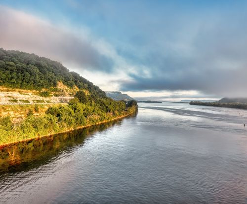 Free Breathtaking view of the Mississippi River's lush banks under cloudy skies in Minnesota. Stock Photo