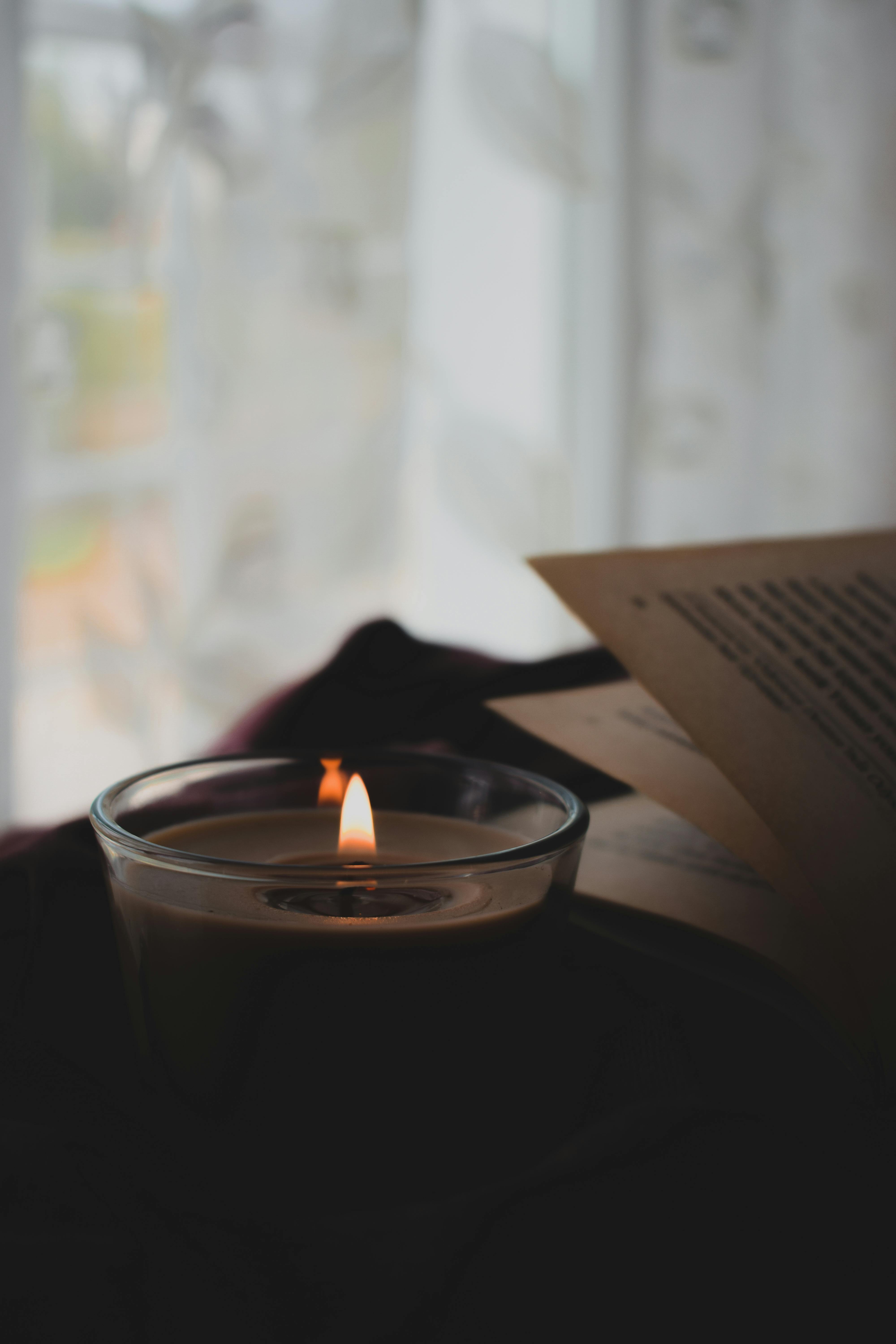 A Lit Candle Near a Book · Free Stock Photo