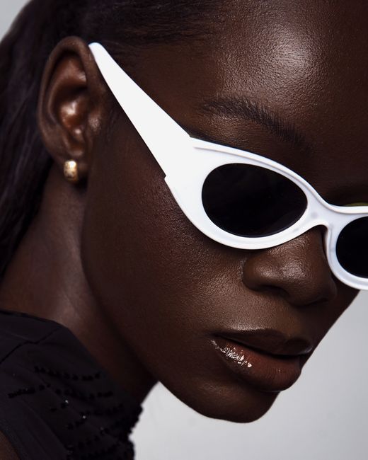 Close-up portrait of a fashionable woman with white sunglasses, exuding modern elegance.