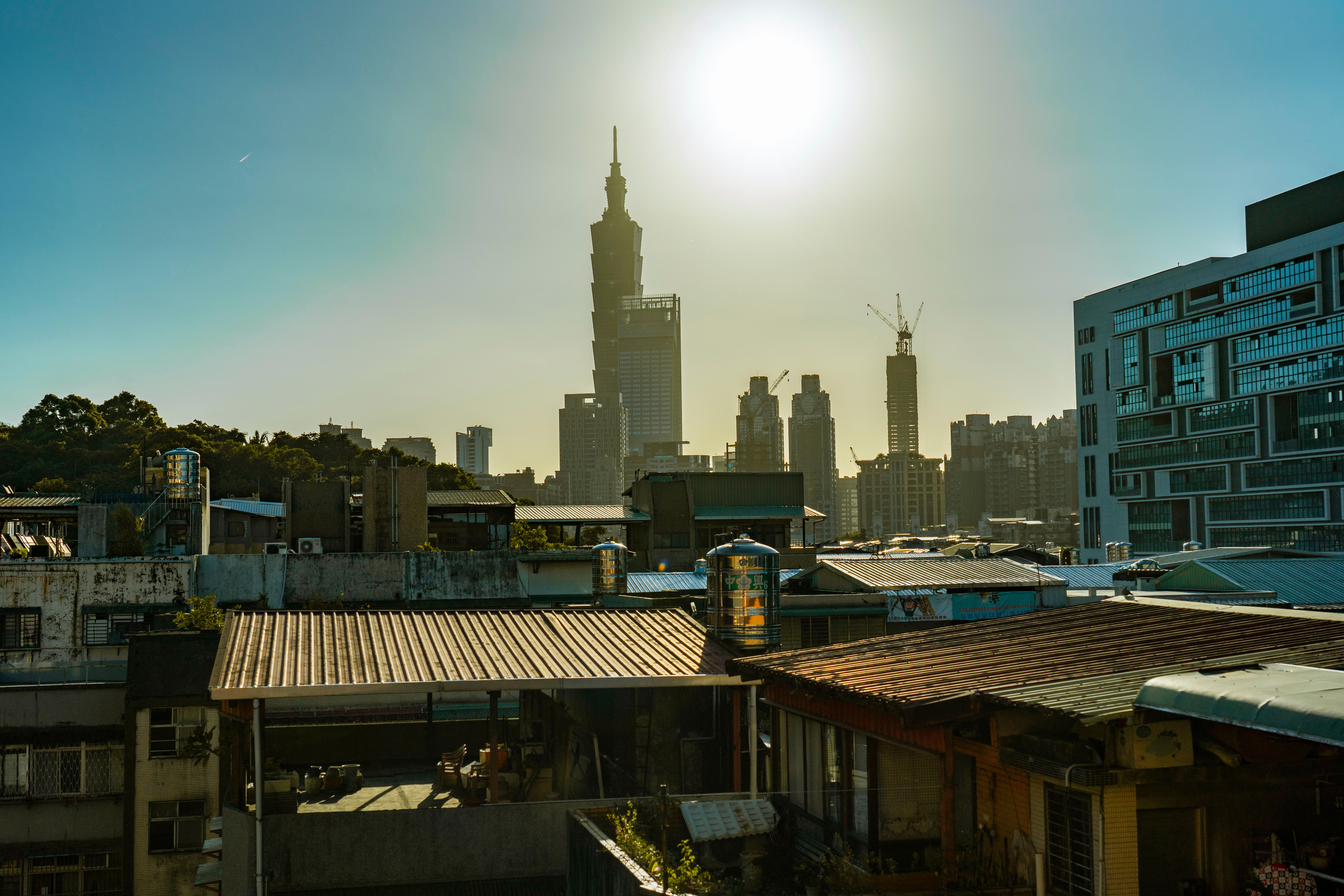 City skyline featuring Taipei 101 under a bright sun, showcasing urban architecture.