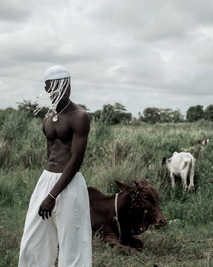 Shirtless Muscular Man Posing Outdoors Wearing A Hat With Braids 