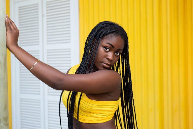 Woman In Yellow Outfit Against A Yellow Wall 