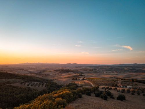 Free A serene aerial view of a sprawling rural landscape under a colorful sunset sky. Stock Photo